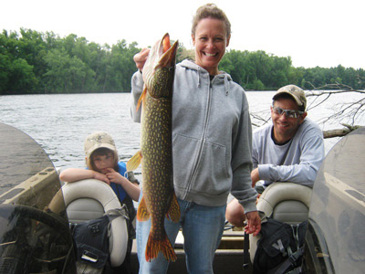 Paula reed with a nice northern pike with her daughter Jaden and husband Jim looking on.