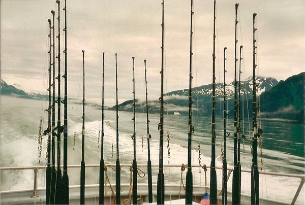 fishing rods hanging off the back of Alaskan fishing boat