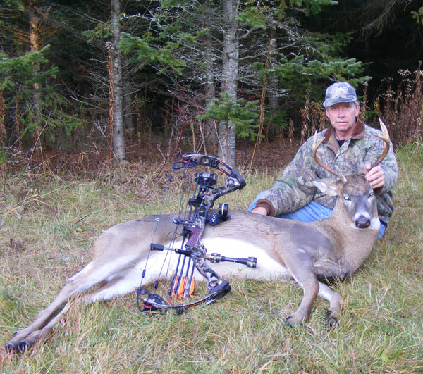 photo of Dan Flood in woods with deer