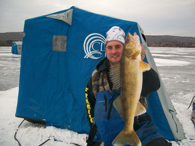 man on ice with walleye